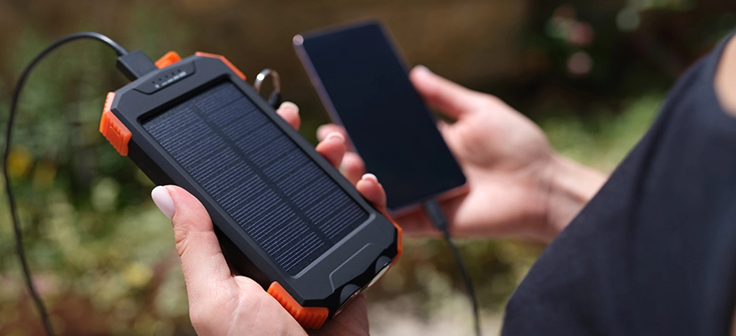 Carregador solar portátil carregando smartphone de forma sustentável