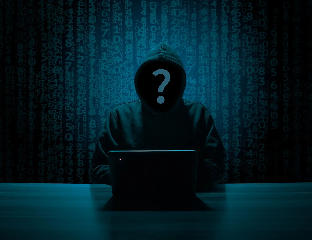 Hacker em sala escura com laptop aberto.